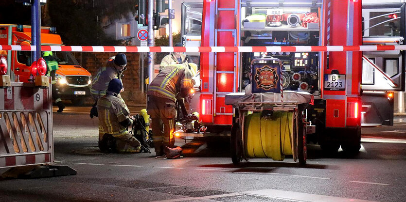 Feuerwehrleute und ein feuerwehrauto vor einem Mietshaus