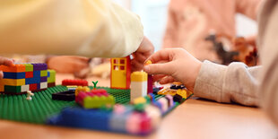 Kinder spielen in einer Kita mit Lego