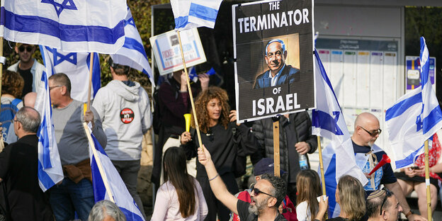 Menschen mit israelischen Fahnen und Plakaten gegen Ministerpräsident Netanjahu