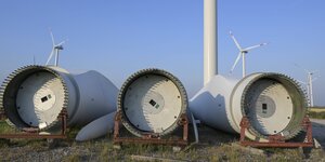 Alte Rotorblätter liegen vor Windkraftanlagen