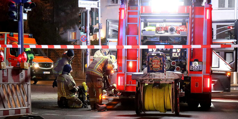 Feuerwehreinsatz vor einem Wohnhaus, im Hintergrund steht ein Krankenwagen