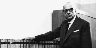 Max Horkheimer steht an einem Bücherregal