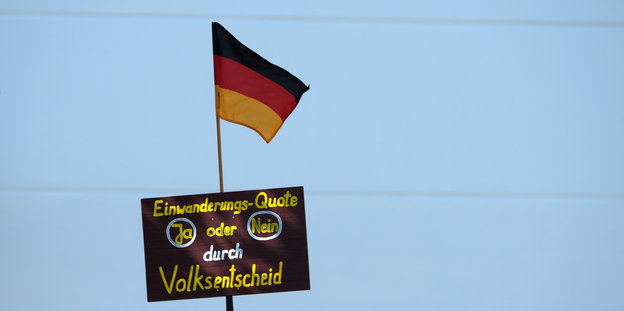 Deutsche Fahne und Schild mit Forderung