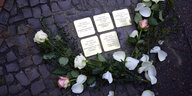 Rosen liegen neben fünf Stolpersteinen, die an die Familie Driesner erinnern