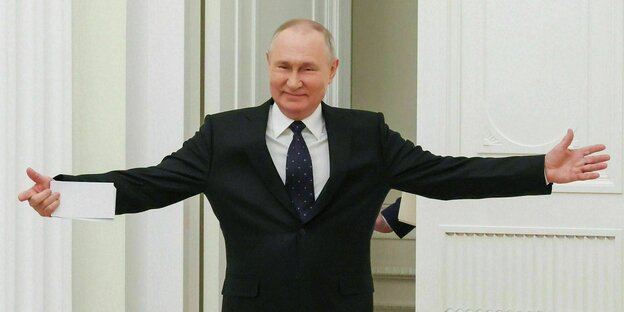 Vladimir Putin enters the conference room with a smile and open arms