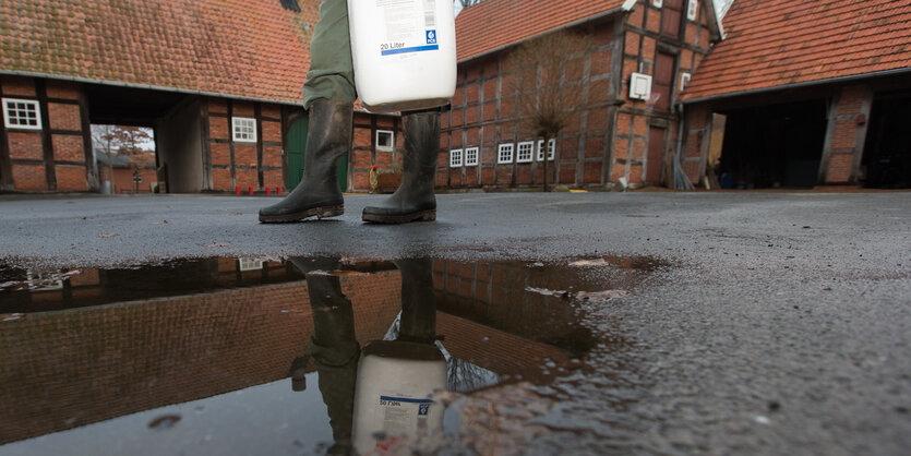 Ein Landwirt trägt einen Kanister mit Pflanzenschutzmittel auf seinem Hof in Badbergen.