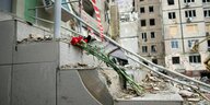 Ein Blumenstrauß liegt vor einem zerstörten Gebäude
