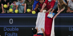 Tennisspieler Daniil Medwedew signiert eine russische Fahne