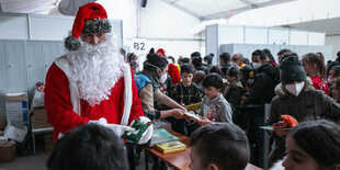 Ein Weihnachtsmann besucht ukrainische Geflüchtete im Ankunftszentrum Berlin Tegel