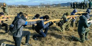 Zivilisten trainieren mit mit Holzattrappen statt echten Waffen