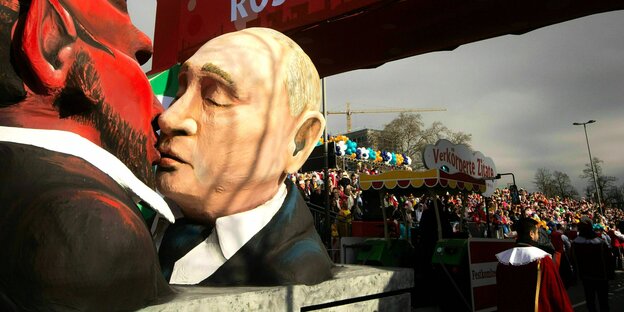Karnevalwagen, der Präsidenten Wladimir Putin küssend mit dem Teufel zeigt.