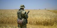 Ein russischer Soldat steht in einem Weizenfeld