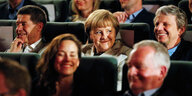 Angela Merkel sitzt lachend in einem Kinositz