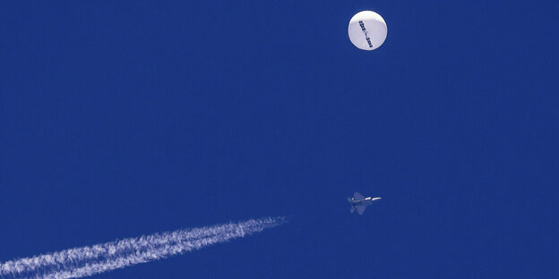 Ein Ballon und Kampfflugzeug ist am Himmel zu sehen