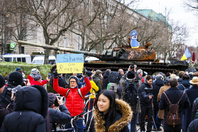 Ein Mann hält ein Schild mit der Aufschrift "Shame on Russia" vor dem Panzer hoch