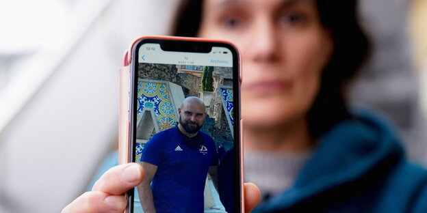 Oihana Goiriena, wife of Pablo Gonzalez, shows a picture of her husband on the smartphone