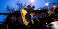 Eine Demonstrantin steht vor einem zerstörten Panzer vor der russischen Botschaft