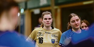 Lea Rühter steht zwischen anderen Spielerinnen in einer Halle.