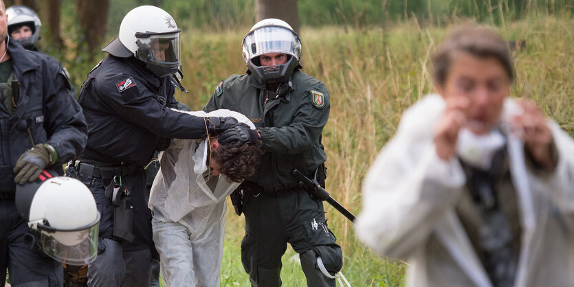 Polizisten führen Demonstranten ab