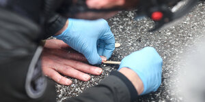 Polizisten lösen die festgeklebten Hände von Aktivisten der Umweltgruppe «Letzte Generation» von der Fahrbahn