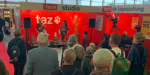 Das Bild zeigt eine Lesung auf einer Buchmesse.