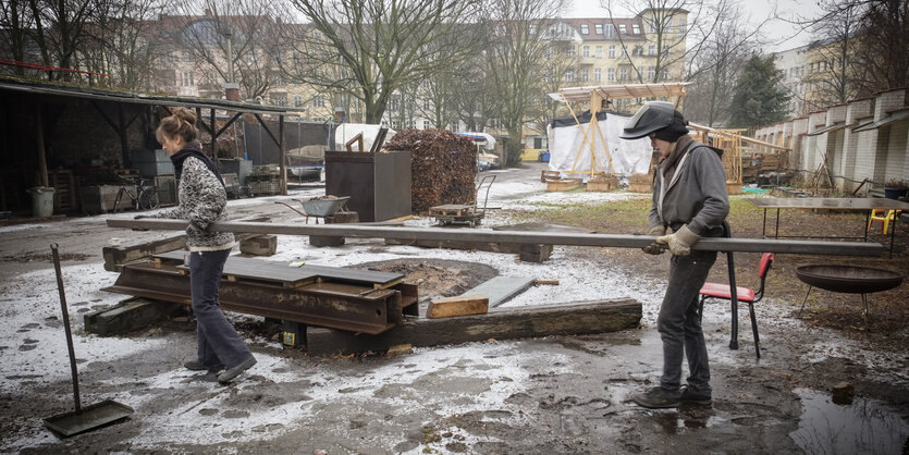 Zwei Menschen tragen einen Stahlträger auf dem Gewerbehof Ratiborstraße 14 in Berlin-Kreuzberg