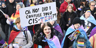 Eine Demo gegen transfeindliche Gewalt. In der Mitte ein Mensch mit einem Schild. Darauf steht "Oh no, did i confuse your cis-tem?"