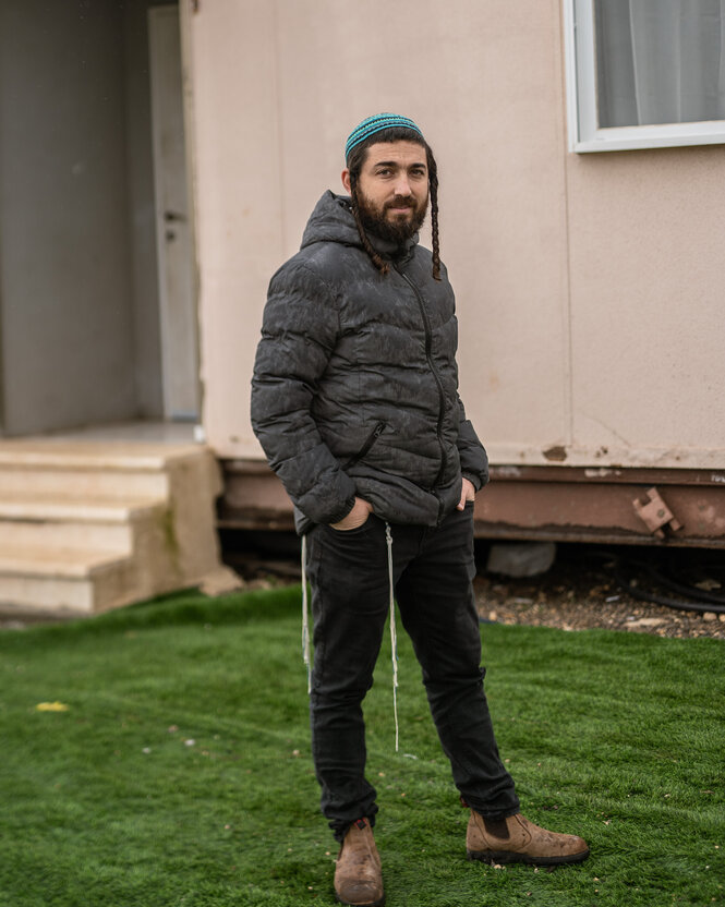 Ein Mann mit Schläfenlocken und Kippa vor einem Haus