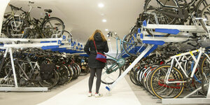 Eine Frau in einem Parkhaus für Fahrräder im Amsterdamer Hauptbahnhof