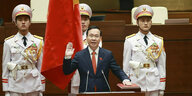 Vo Van Thuong hebt die Hand während seiner Vereidigung, hinter ihm stehen stramm drei Soldaten in heller Uniform