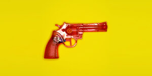 Eine rote Spielzeug-Wasserpistole auf gelbem Hintergrund