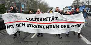 Eine Menschengruppe hält einen Banner worauf Steht Solidarität mit den Streikenden der KVB