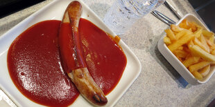 Ein Teller Currywurst mit Pommes in einer Kantine