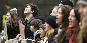 Junge Menschen stehen hinter Transparent bei einer Demonstration