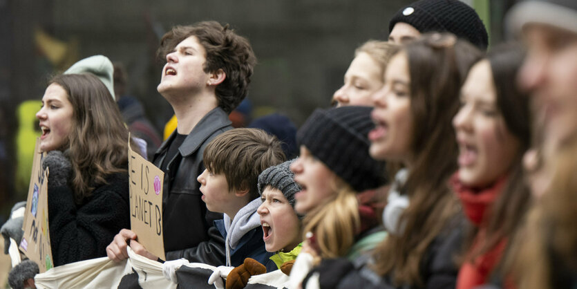 Junge Menschen stehen hinter Transparent bei einer Demonstration