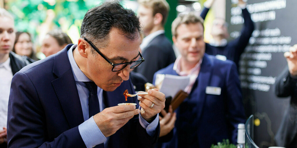 Bundesagrarminister Cem Özdemir (M, Bündnis 90/Die Grünen) probiert während eines Messerundgangs auf der Messe Biofach veganes Gyros.