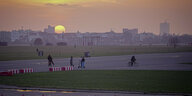 Menschen auf dem Tempelhofer Feld vor dem Sonnenuntergang