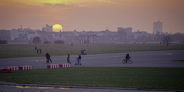 Menschen auf dem Tempelhofer Feld vor dem Sonnenuntergang