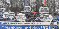 Fans des VfB Oldenburg mit Transparenten: Pro Neubau, richtigeFlutlichtspiele, Dauerhafter Standort