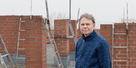 Porträt eines Menschen, der zwischen Schornsteinen auf einem Dach steht