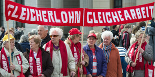 Eine Gruppe älterer Frauen hält ein Transparent mit dr Aufschrift "Gleicher Lohn für gleiche Arbeit"