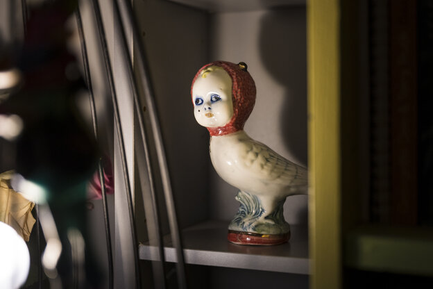 Eine Porzellanfigur - ein Huhn mit Babykopf und Kopftuch