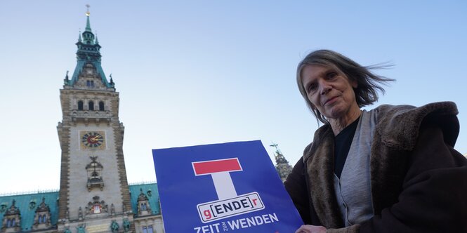 Eine weiblich gelesene Person hält vor dem Hamburger Rathaus ein Plakat der Aufschrift g(ENDE)r - Zeit zum Wenden