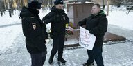 Ein Mann protestiert in Moskau gegen den Krieg und wird von der Polizei angehalten
