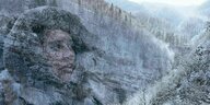 Ein verschneiter bewaldeter Berghang, eine weibliche Figur mit Fellmütze ist schemenhaft zu erkennen