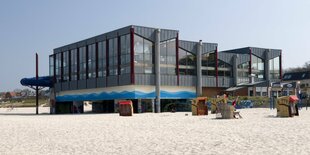 Kastenförmiges Gebäude mit vielen Fenstern am Strand