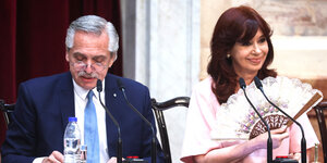 Cristina Kirchner fächert sich zu und der Präsident Alberto Fernandes schaut auf sein Wasser, das auf dem Tisch steht