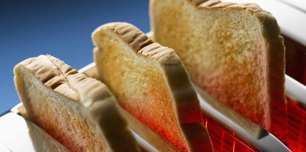 Im Toaster stecken drei Scheiben Brot.