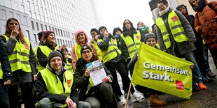 Menschen in gelben Gewerkschaftswesten sitzen auf der Straße