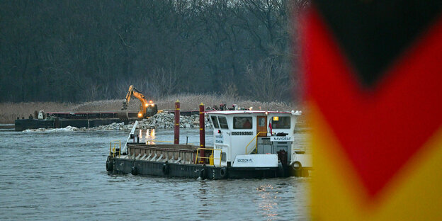 Ein Schiff ist am frühen Morgen unterwegs zur Baustelle an einer Buhnen auf der polnischen Uferseite de Oder